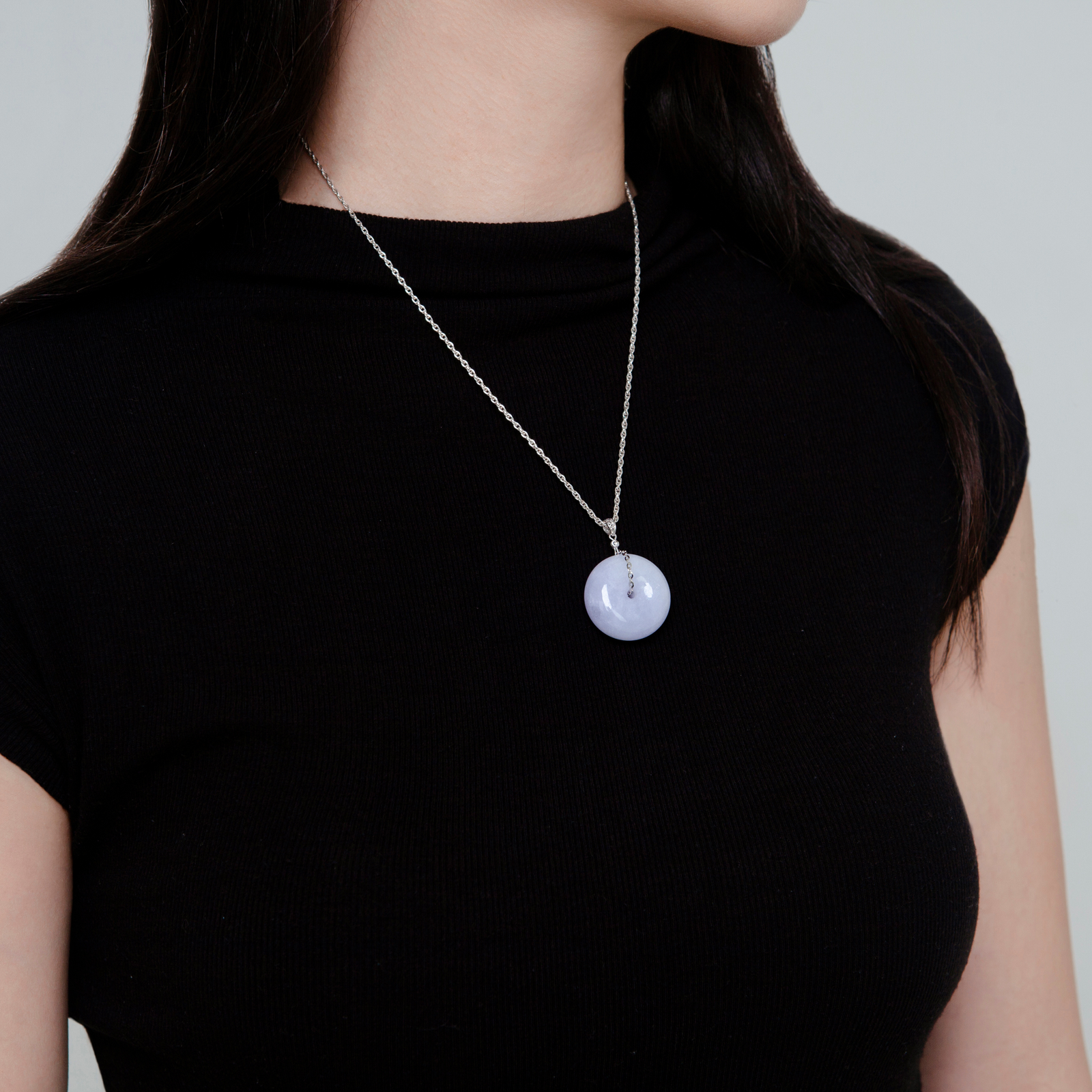 Purple lavender jade pendant shaped like a Chinese amulet with diamond decoration