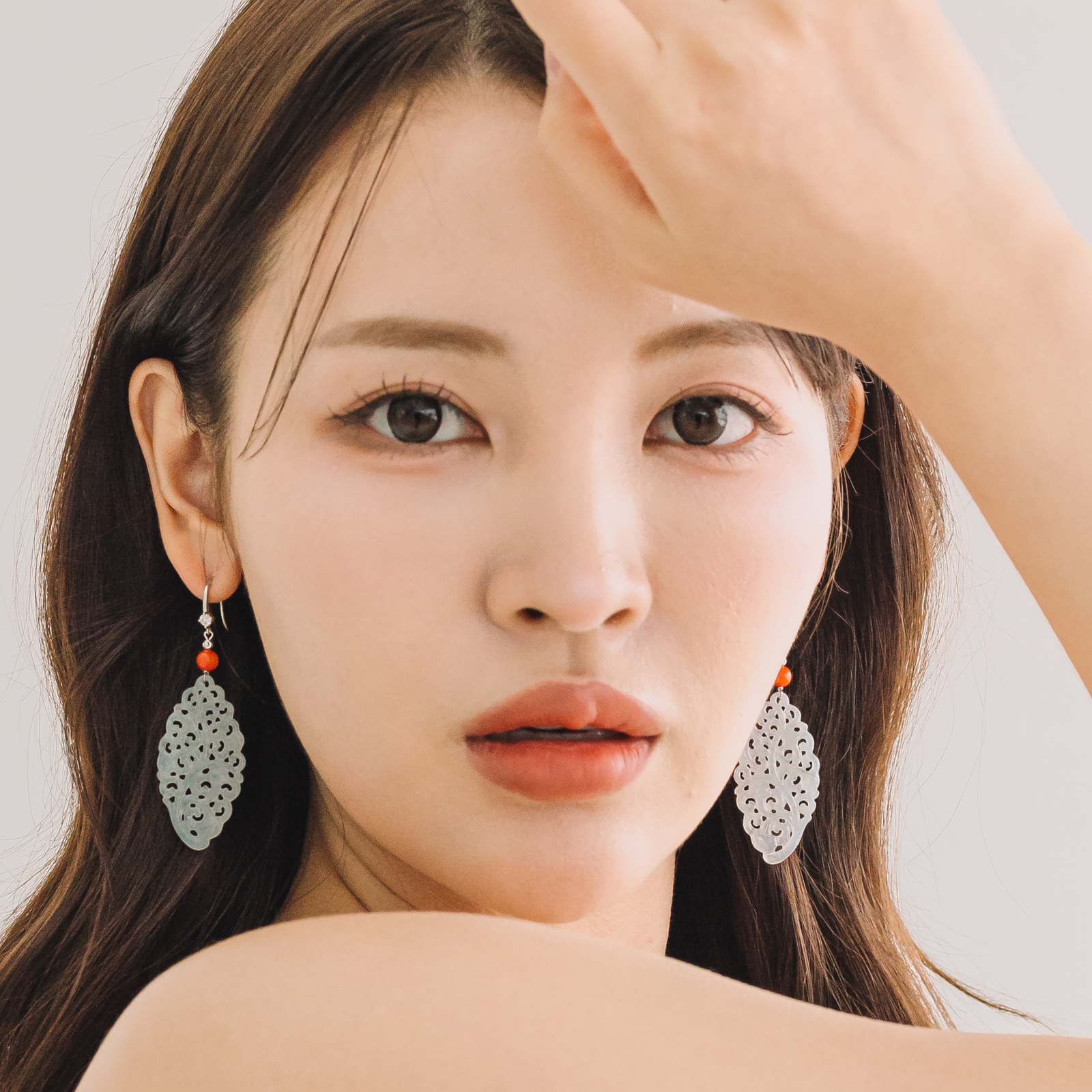 White jade earrings in a lotus pattern, decorated with coral and diamonds