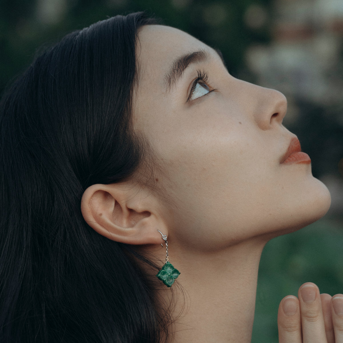 Woman praying wearing beautiful jade earring