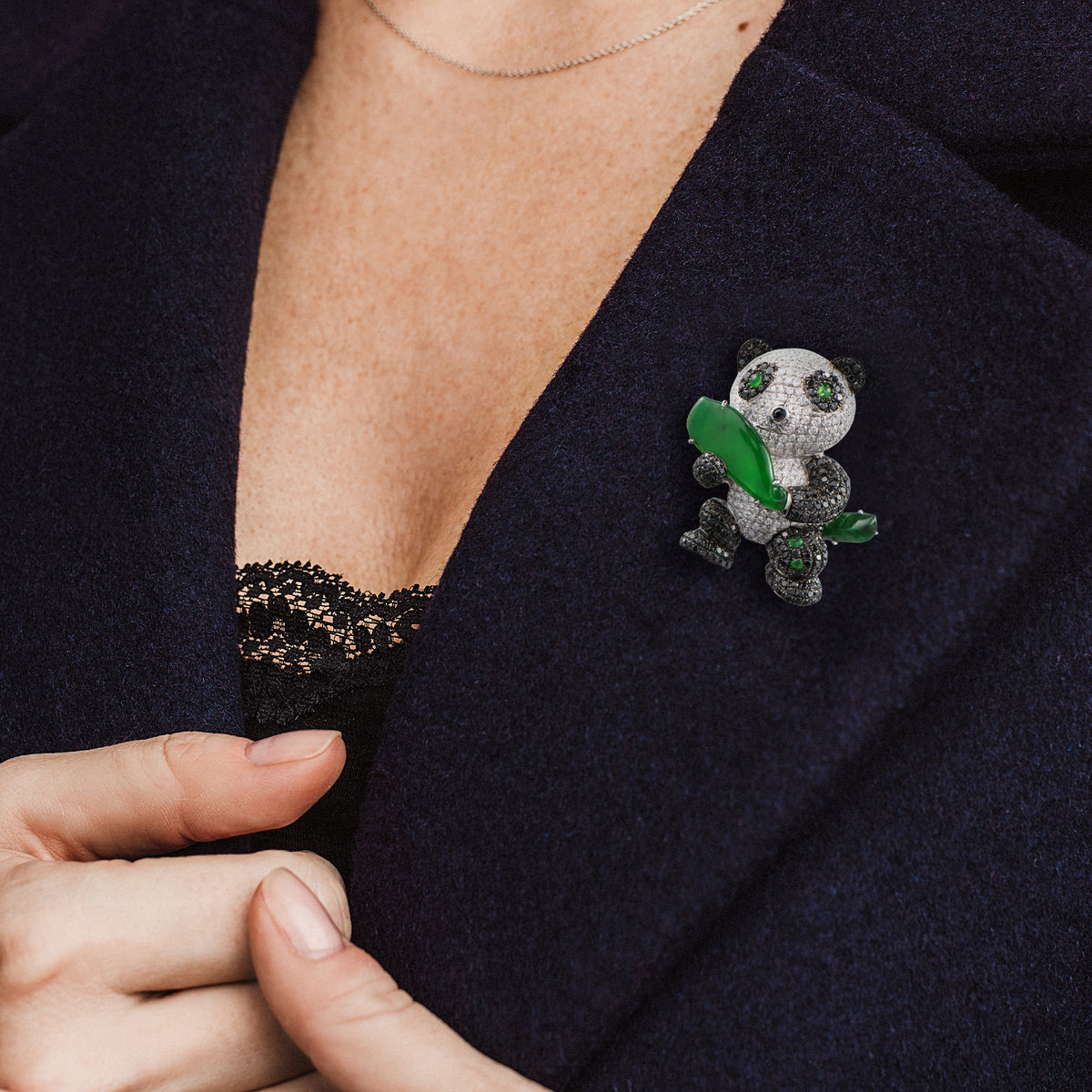 Woman wearing jade and diamond statement brooch on her suit